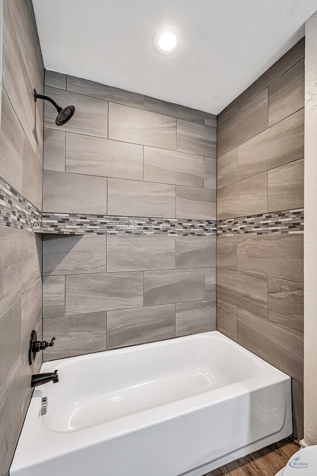 bathroom featuring hardwood / wood-style floors and tiled shower / bath