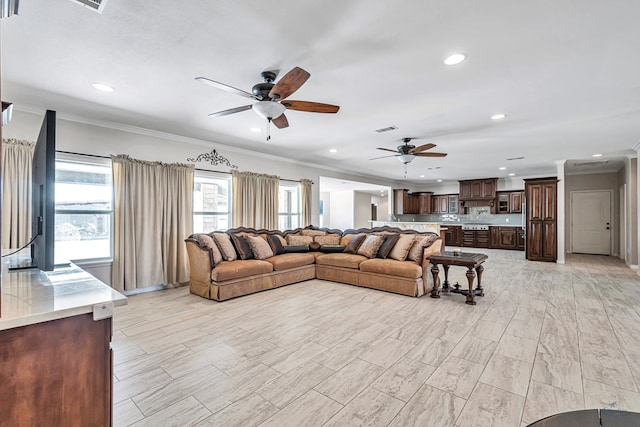 living room with ceiling fan and crown molding