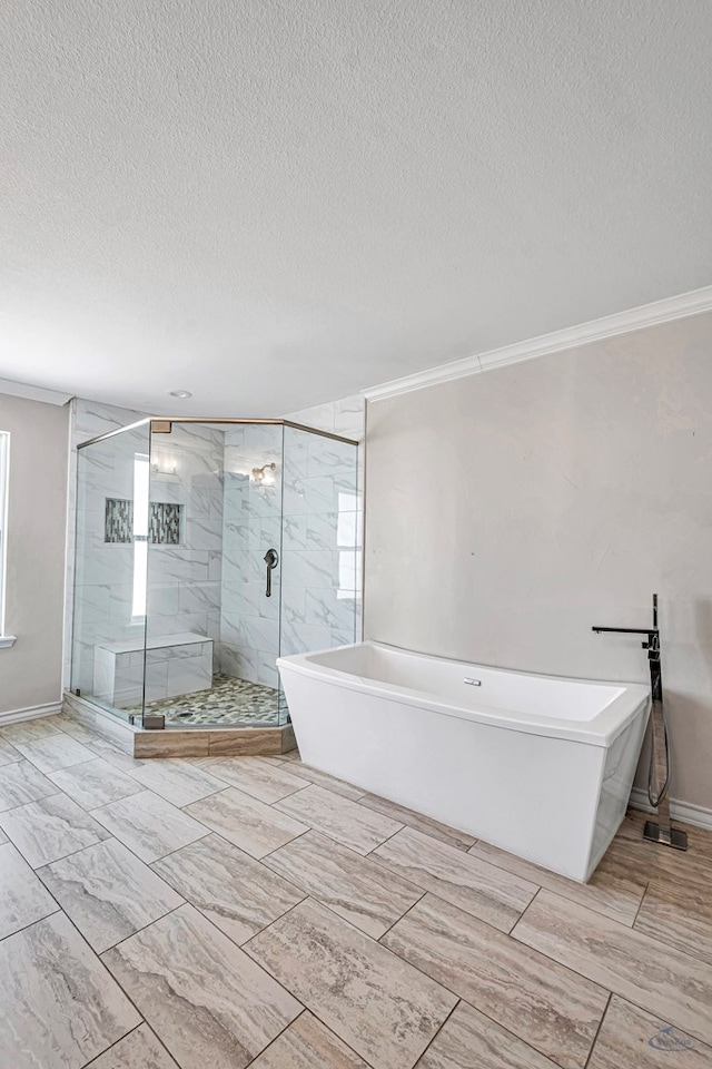 bathroom featuring a textured ceiling, separate shower and tub, and ornamental molding