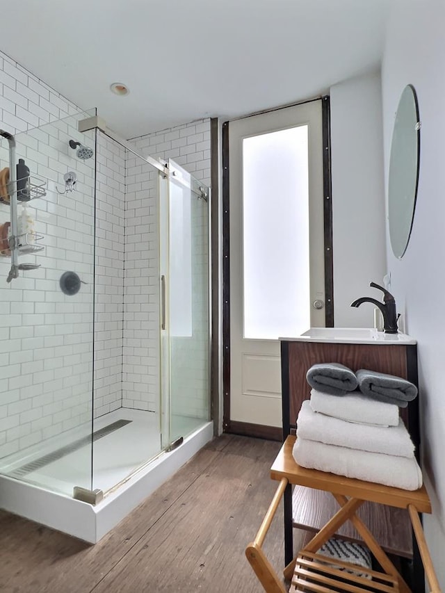 bathroom with vanity, a shower with shower door, and hardwood / wood-style flooring