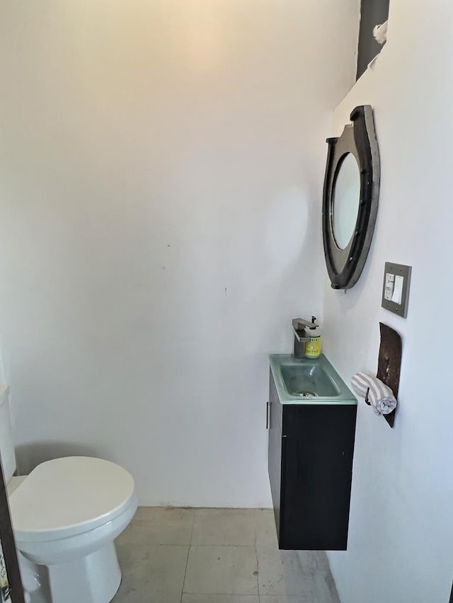 bathroom featuring tile patterned flooring, vanity, and toilet