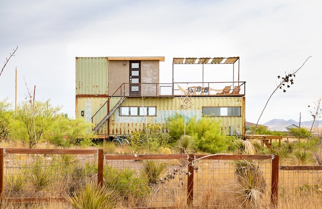 back of house with a mountain view and a balcony