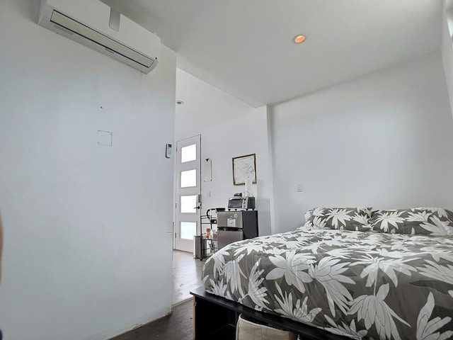 bedroom featuring a wall mounted AC and dark wood-type flooring