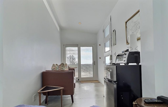 kitchen featuring stainless steel fridge and lofted ceiling