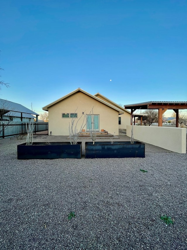 view of side of home featuring stucco siding and fence