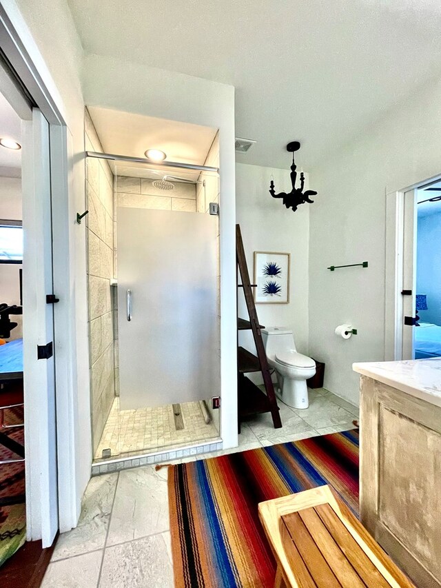 bathroom featuring vanity, visible vents, an inviting chandelier, a stall shower, and toilet