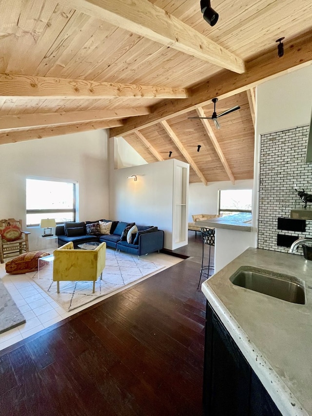 interior space featuring hardwood / wood-style flooring, vaulted ceiling with beams, wooden ceiling, and a sink