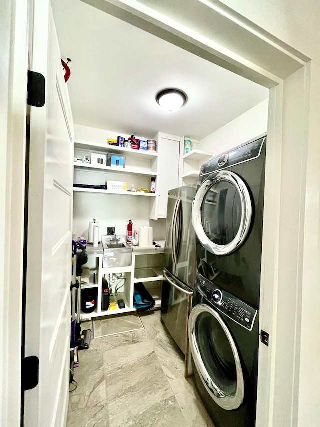 washroom featuring stacked washer and dryer and laundry area