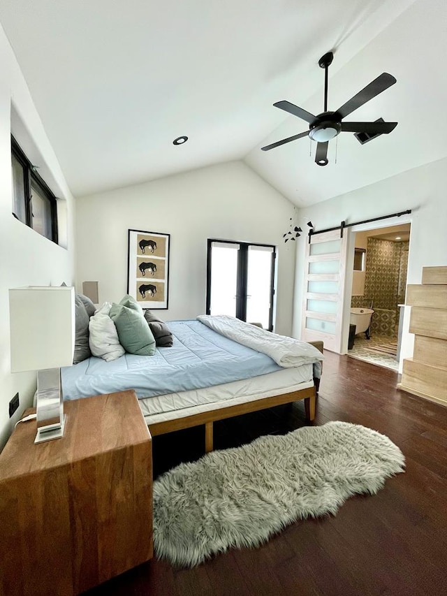 bedroom with connected bathroom, ceiling fan, a barn door, lofted ceiling, and wood finished floors