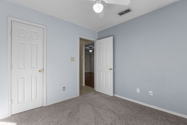 unfurnished bedroom with light carpet, baseboards, visible vents, ceiling fan, and a textured ceiling