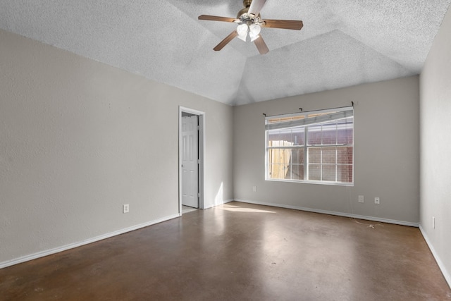 unfurnished room featuring lofted ceiling, ceiling fan, a textured ceiling, concrete floors, and baseboards