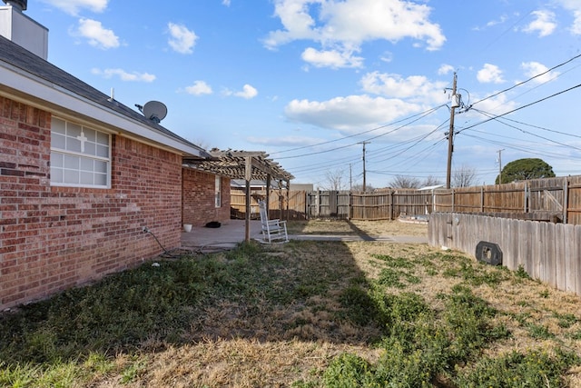 view of yard featuring a patio area, a fenced backyard, and a pergola