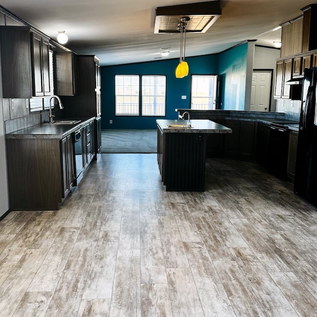 kitchen featuring dark brown cabinetry, sink, a kitchen island, pendant lighting, and black appliances