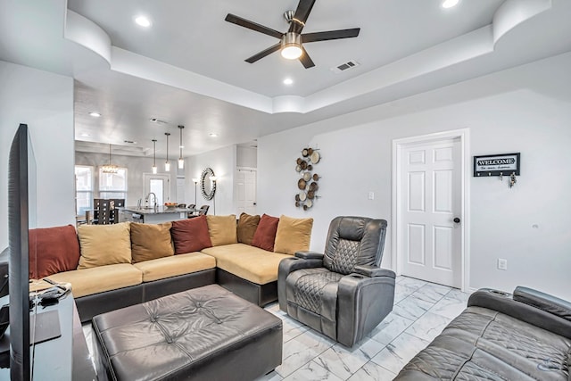 living room featuring recessed lighting, a ceiling fan, visible vents, marble finish floor, and a tray ceiling