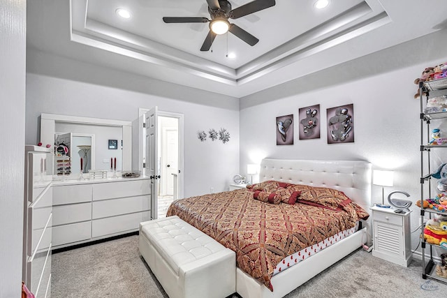 bedroom with light carpet, ceiling fan, a raised ceiling, and recessed lighting