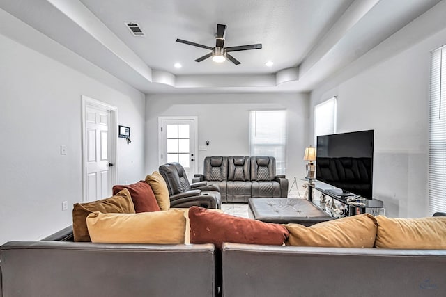 living room featuring ceiling fan, visible vents, a tray ceiling, and recessed lighting