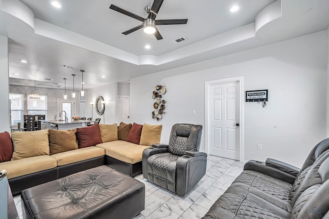 living area featuring visible vents, a ceiling fan, marble finish floor, a tray ceiling, and recessed lighting