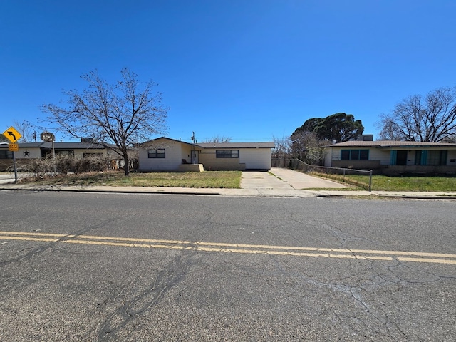 view of front of house with a front yard, fence, a garage, and driveway