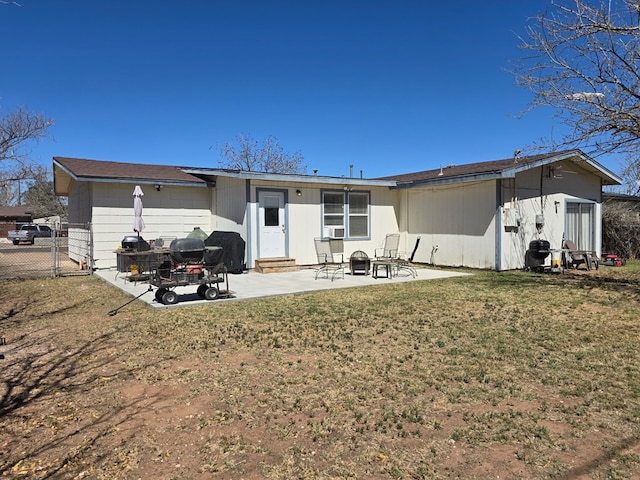 back of property featuring entry steps, a patio, fence, and a lawn