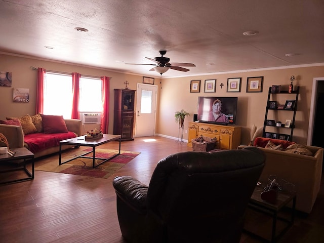 living room with wood finished floors, a textured ceiling, ornamental molding, and a ceiling fan