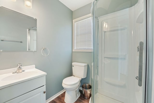 bathroom with vanity, toilet, an enclosed shower, and wood-type flooring