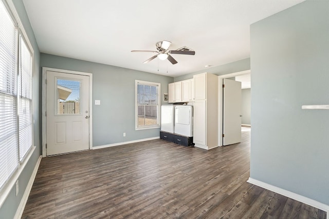 unfurnished living room featuring washing machine and clothes dryer, ceiling fan, dark wood-type flooring, and a healthy amount of sunlight