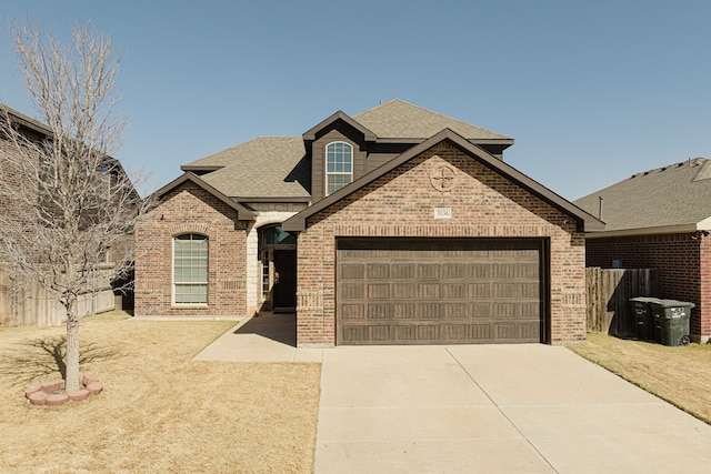 view of front facade with concrete driveway, roof with shingles, an attached garage, fence, and brick siding