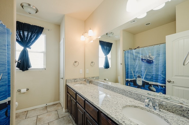 bathroom with toilet, a sink, and tile patterned floors