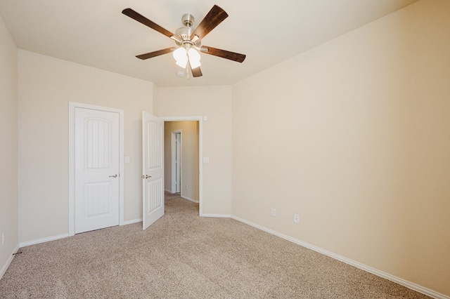 unfurnished bedroom featuring light carpet, baseboards, and a ceiling fan