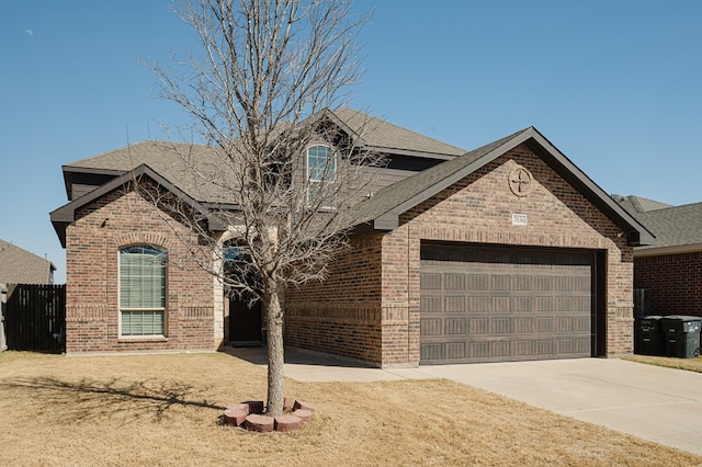 view of front of property with an attached garage, brick siding, a shingled roof, fence, and driveway