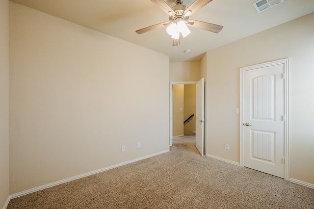 unfurnished bedroom with a ceiling fan, light colored carpet, visible vents, and baseboards