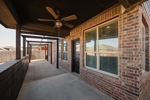 view of patio with fence and a ceiling fan