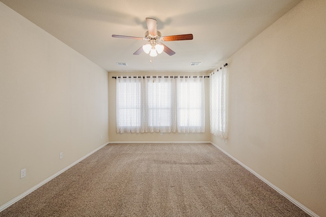 unfurnished room with light carpet, baseboards, visible vents, and ceiling fan