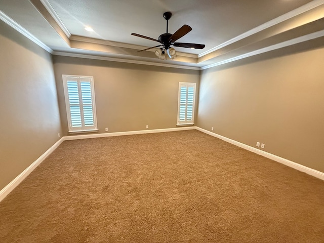 unfurnished room with carpet floors, a tray ceiling, and baseboards