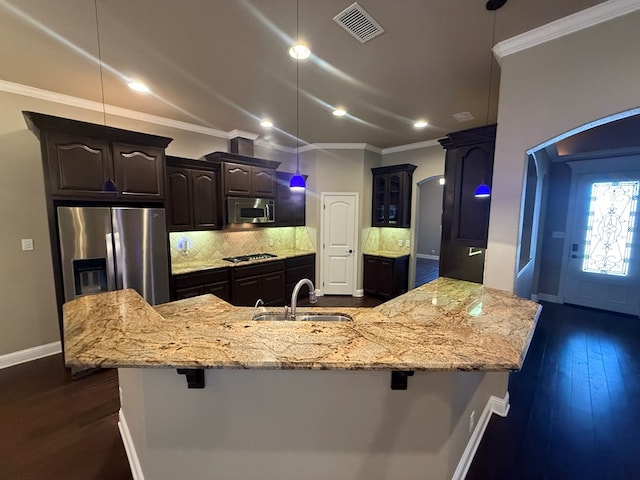 kitchen with stainless steel appliances, a breakfast bar, a sink, and crown molding