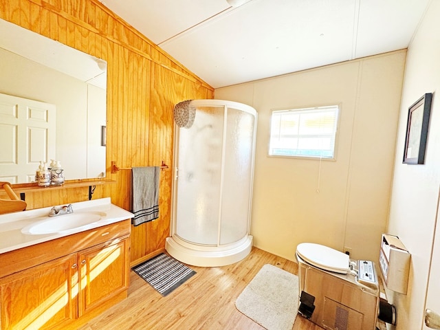 bathroom featuring hardwood / wood-style flooring, vanity, a shower with door, and vaulted ceiling