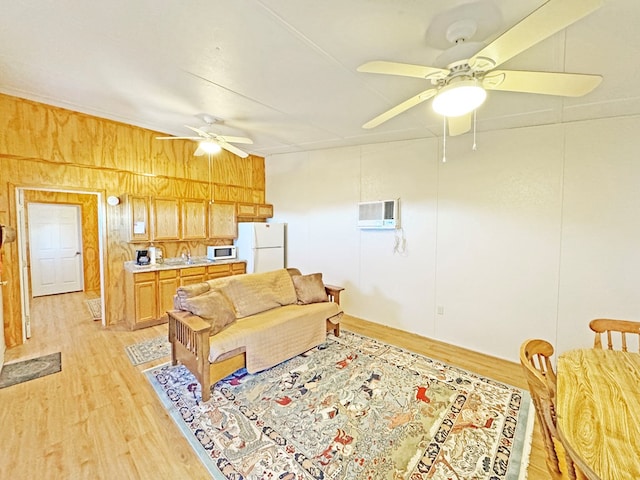 living room featuring light hardwood / wood-style flooring, wood walls, and a wall unit AC