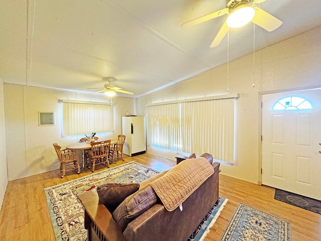 living room featuring ceiling fan, wood-type flooring, and vaulted ceiling