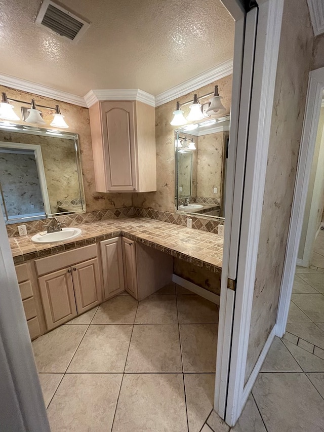 bathroom featuring tile patterned flooring, vanity, crown molding, and a textured ceiling