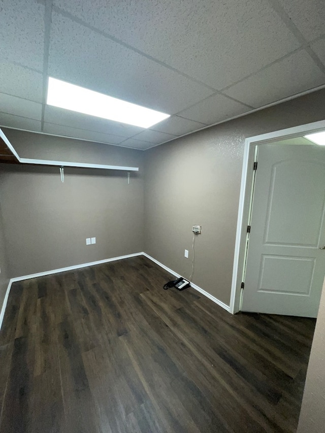 basement featuring a drop ceiling and dark hardwood / wood-style flooring