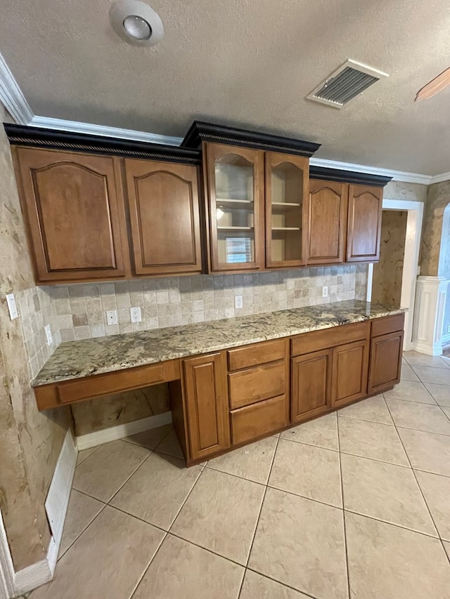 kitchen with a textured ceiling, tasteful backsplash, and crown molding