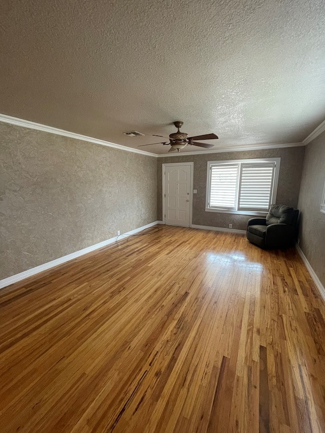 interior space featuring crown molding, light hardwood / wood-style flooring, ceiling fan, and a textured ceiling