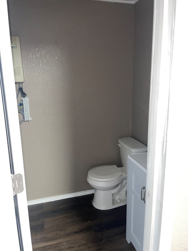 bathroom featuring wood-type flooring, vanity, and toilet