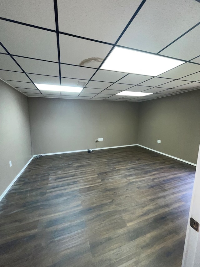 basement with a paneled ceiling and dark hardwood / wood-style flooring