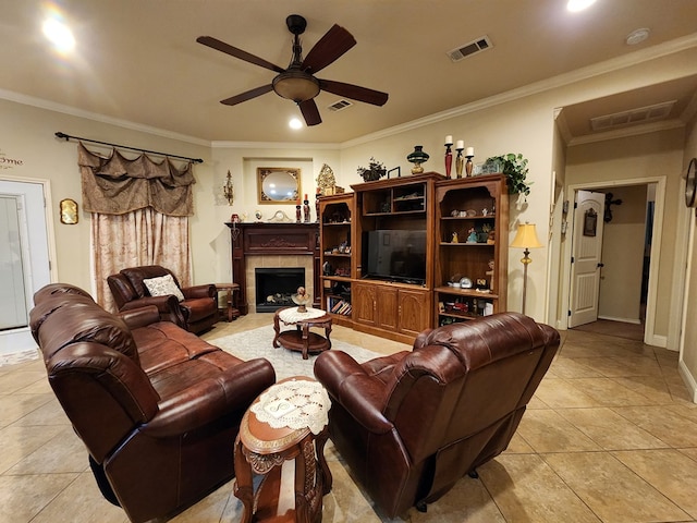 living room featuring ornamental molding, light tile patterned floors, a fireplace, and ceiling fan