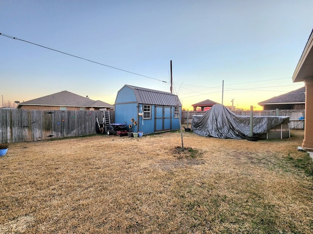 yard at dusk with a covered pool and a shed