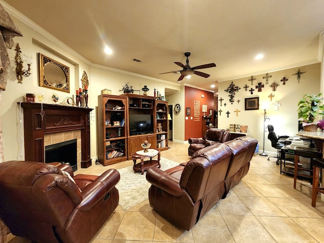 living room featuring light tile patterned floors, a fireplace, ornamental molding, and ceiling fan