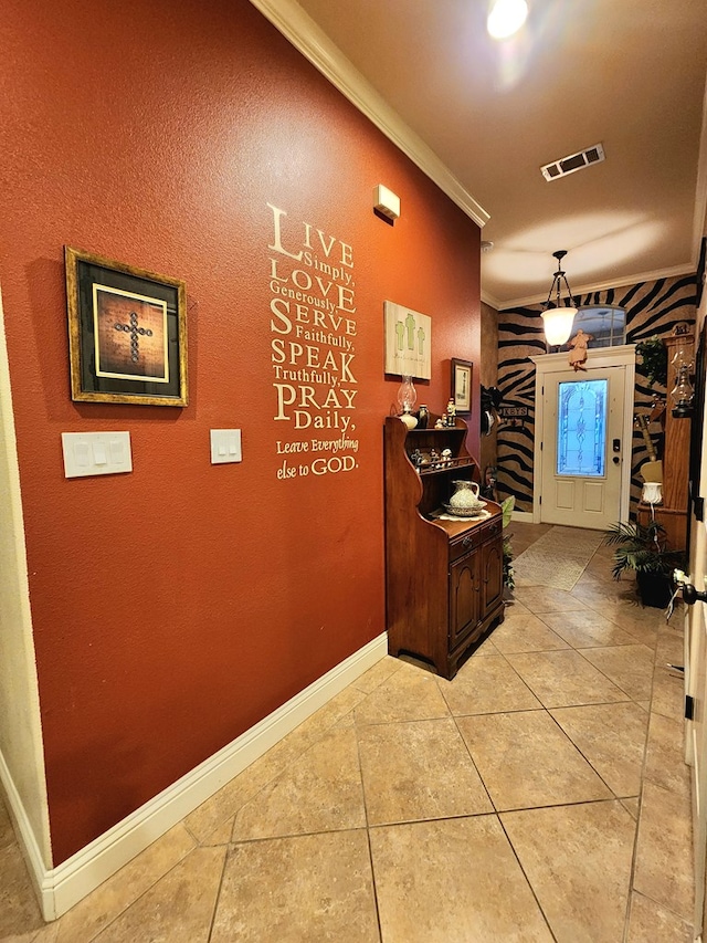 hallway with ornamental molding and light tile patterned floors