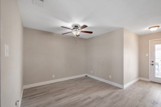 spare room featuring light wood-style flooring, visible vents, ceiling fan, and baseboards