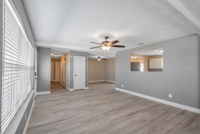 unfurnished room featuring light wood-style floors, visible vents, and baseboards